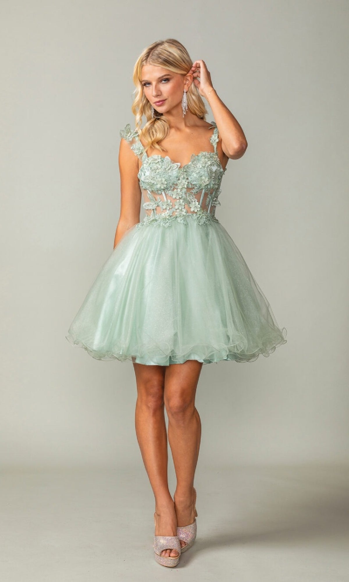 Woman wearing a light green a-line short dress on a plain background